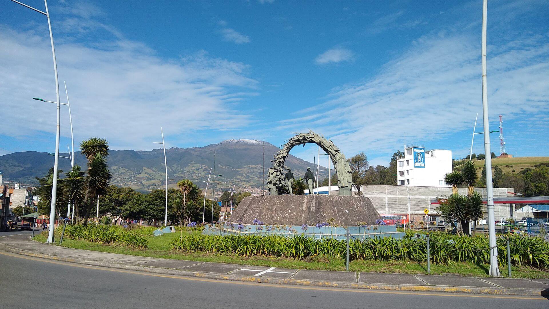 Amplia vista desde el monumento al campesino de fondo el volcán Galeras y un cielo azul parcialmente nublado.