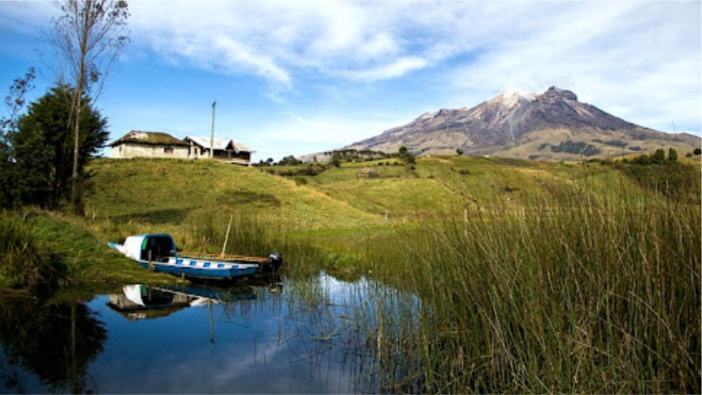 Una lancha en el muelle, rodeado de agua y con el volcan cumbal al fondo.