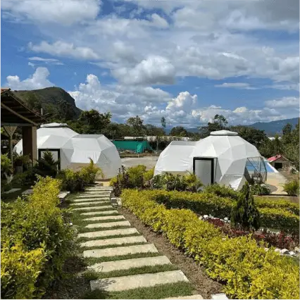 Un paisaje con cúpulas blancas y vegetación exuberante.